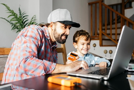 Image showing father figure with young son shopping online on laptop computer