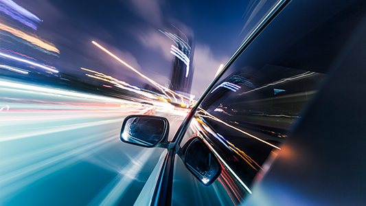 Side of car driving on the road in blurred motion.