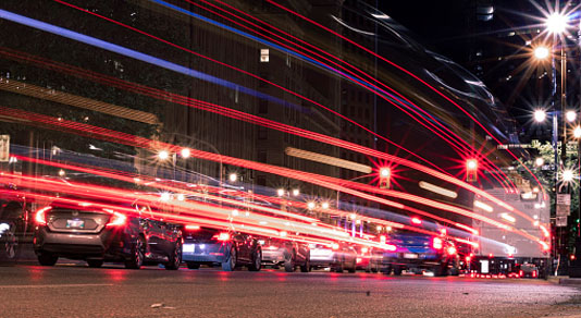 Cars driving at night, blurred lights from taillights.