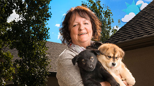 Woman holding two puppies