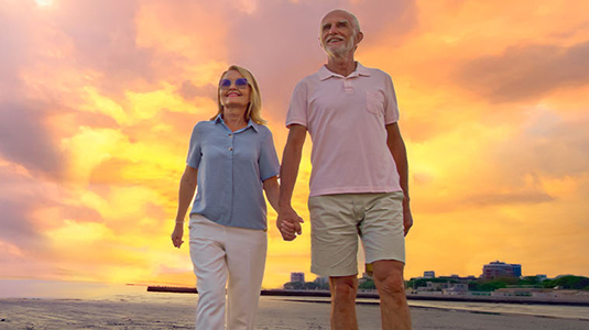 Couple walking on the beach during a sunset