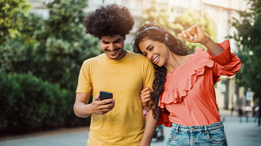 A couple of teenagers looking at a phone