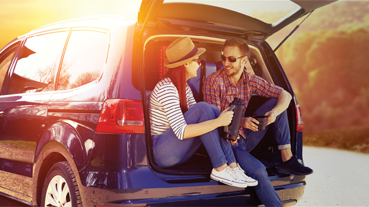 A young couple sitting in the back of a van