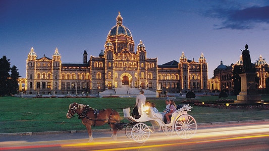 Two couples being pulled in a horse-drawn carriage at night.