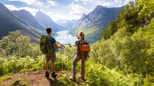 Couple overlooking a mountain and valley scene.
