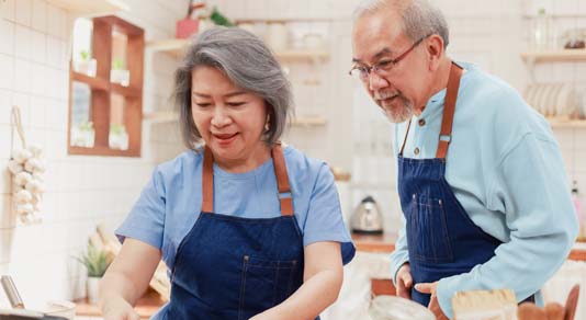 Cheerful senior couple cooking food together