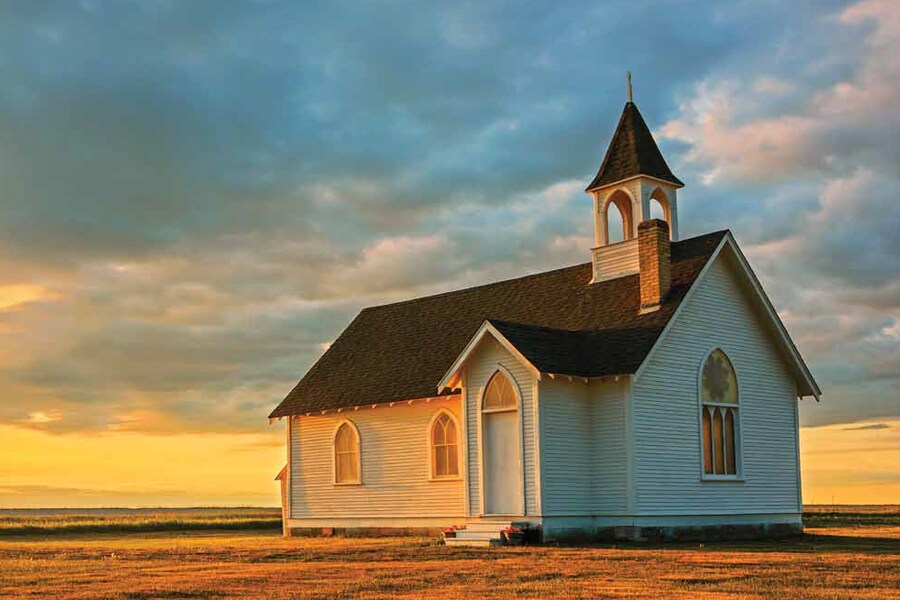 Image showing a small wooden church standing alone on a prairie landscape.