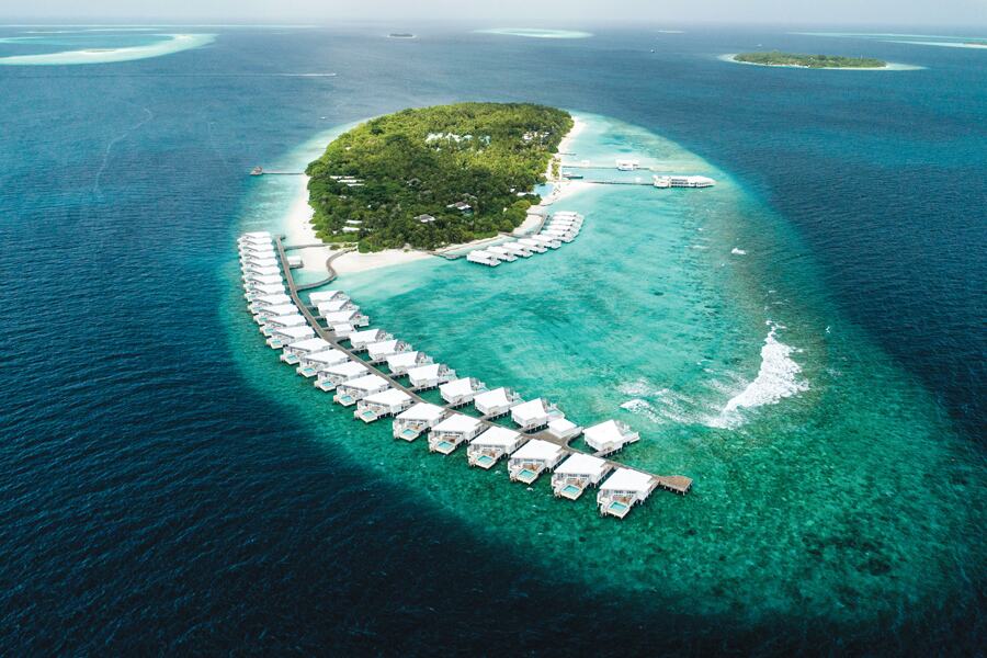 Image showing small island with rows of tourist cabins built into the island reef.