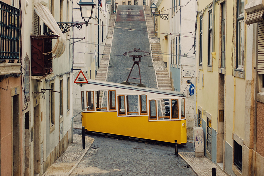 Images showing a small streetcar climbing a sloped street in Lisbon.
