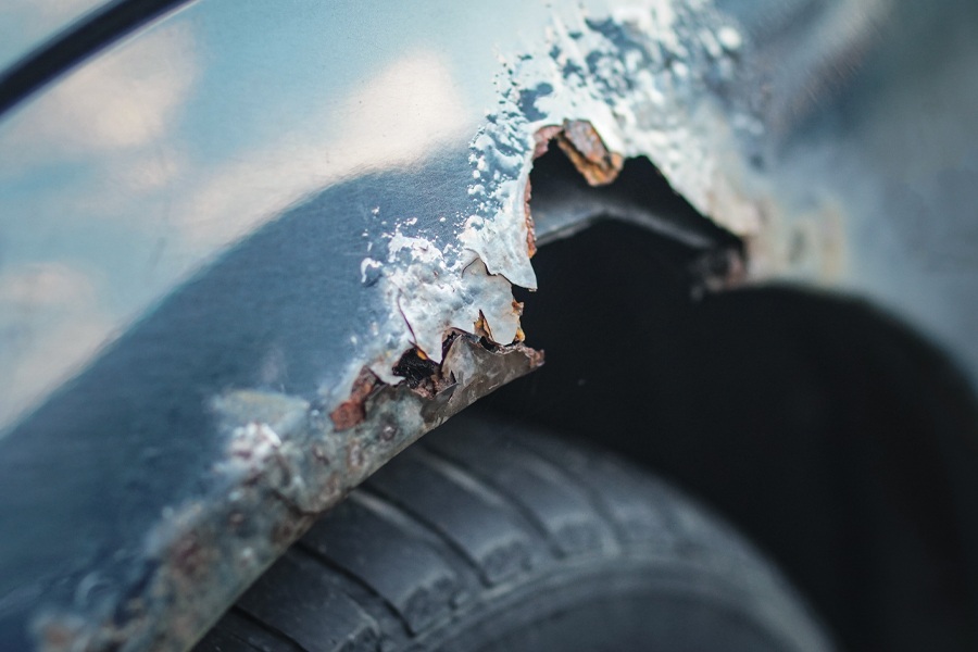 Image showing jagged metal eaten away by heavy rust on a vehicle quarter panel.