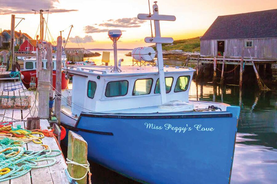 Photo showing typical Atlantic Canada harbour scene with fishing boat, lobster traps and outbuildings.