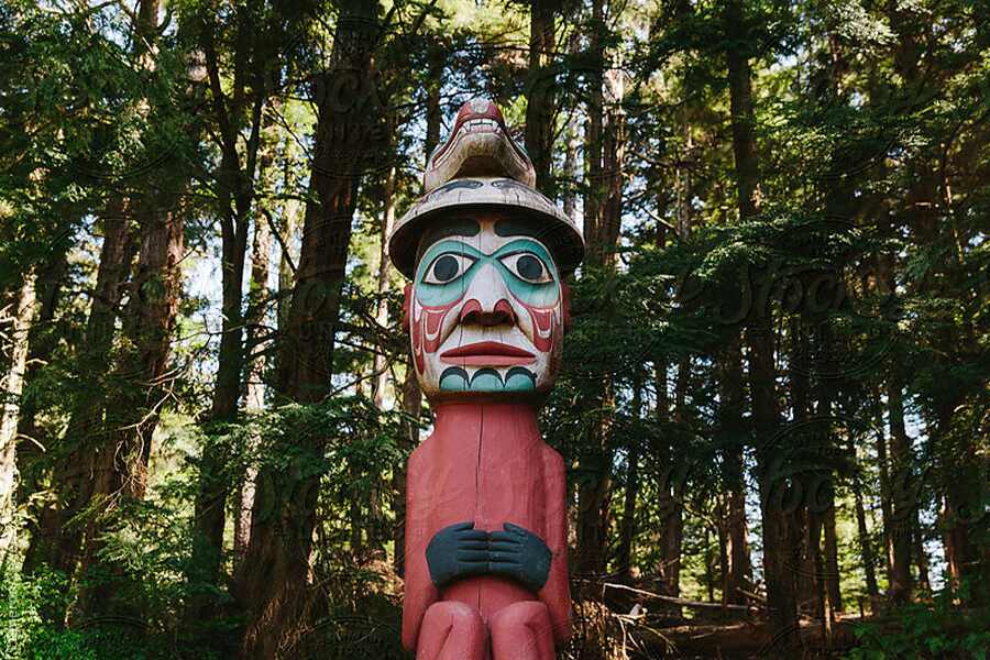 Image showing colourful native totem pole in dense forest.