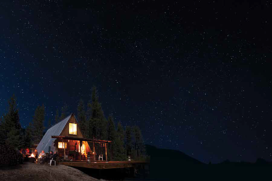 Photo showing a chalet-style cabin lit up at night.