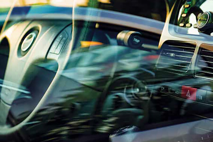 Photo showing interior of a car from outside the side window vehicle glass.