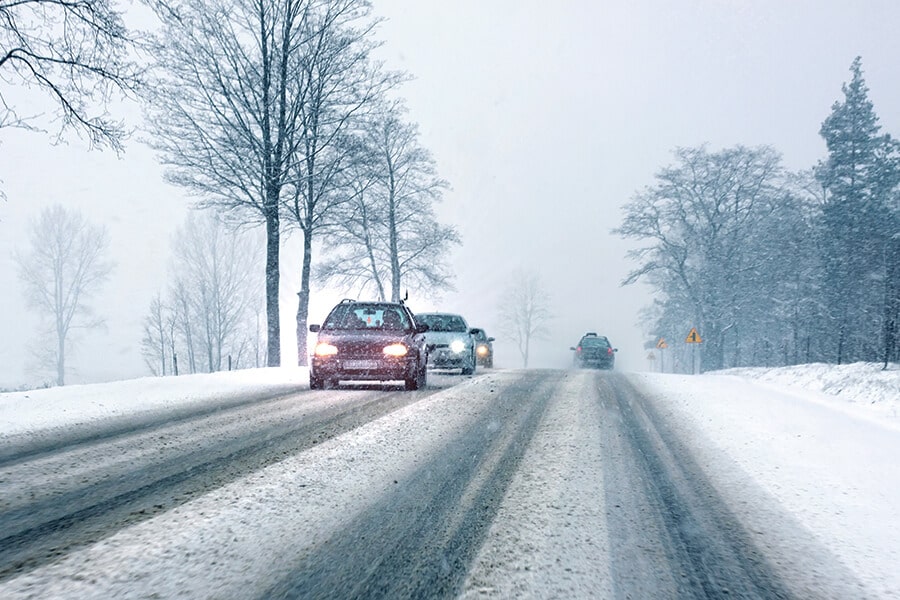 Image showing a snowy highway with a line of cars.