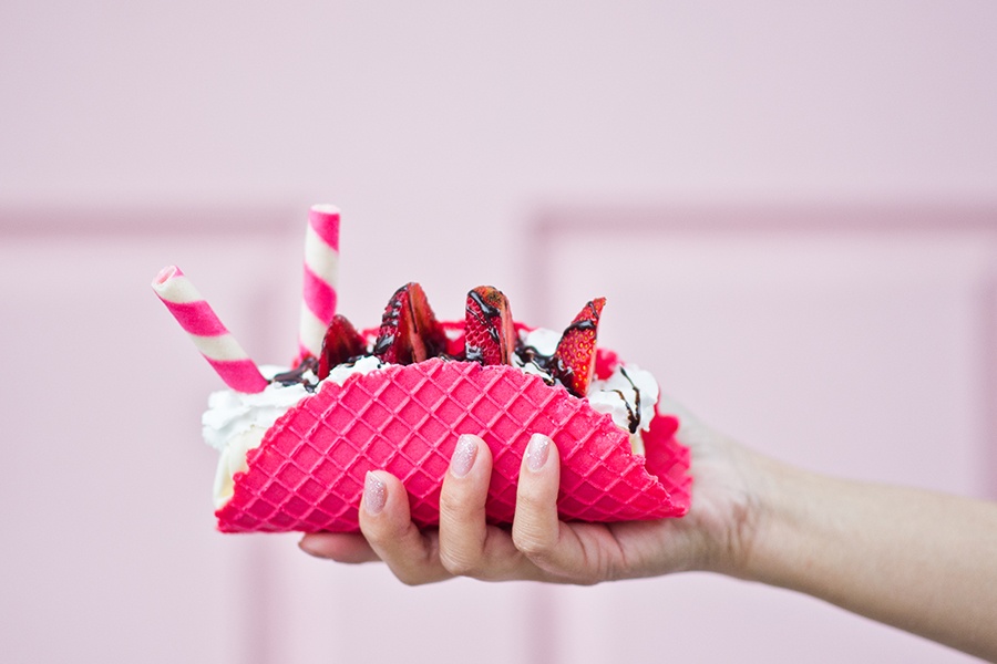 Image showing a hand holding an ice cream treat with strawberries and candy canes.