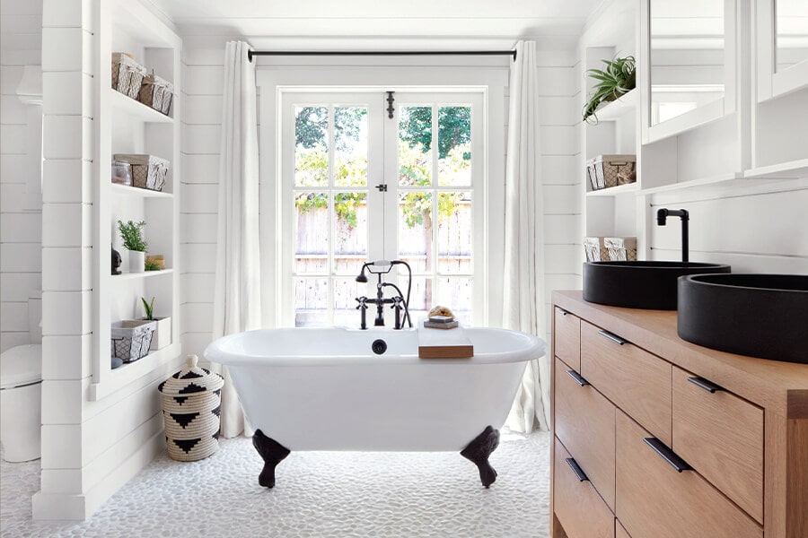 Image showing rustic looking bathroom in white with an old-style clawfoot bathtub in the centre.