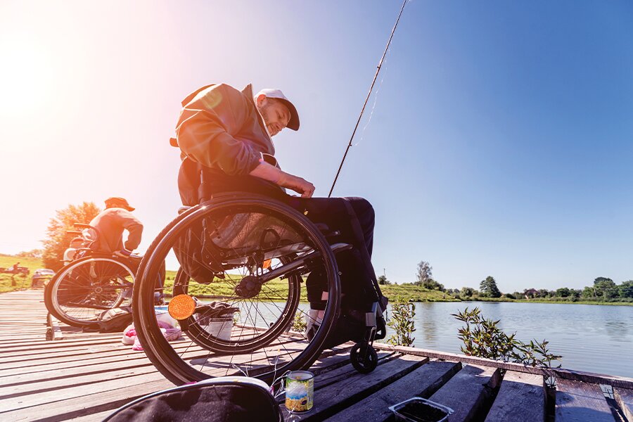 Image showing a man in a wheelchair fishing off a dock.