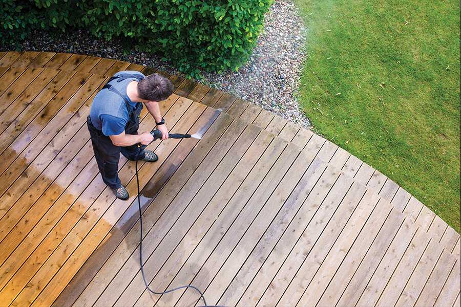 Image showing an overhead view of a man power washing a wooden deck.