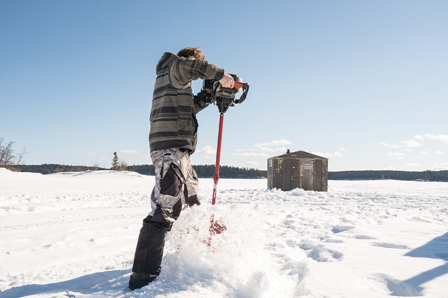 Image showing a man ice fishing on a frozen lake.