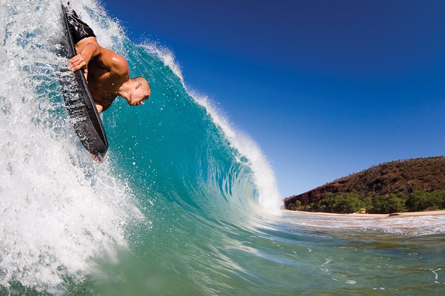 Image showing a man riding a surfboard down a large wave.