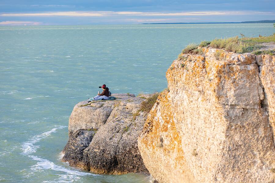 Image showing a person sitting on a rock overlooking the lake at Steep Rock, Manitoba.