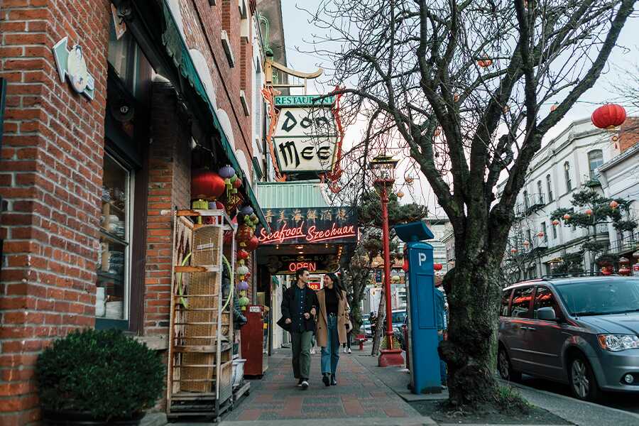 Image showing a couple walking past buildings in colourful Chinatown.