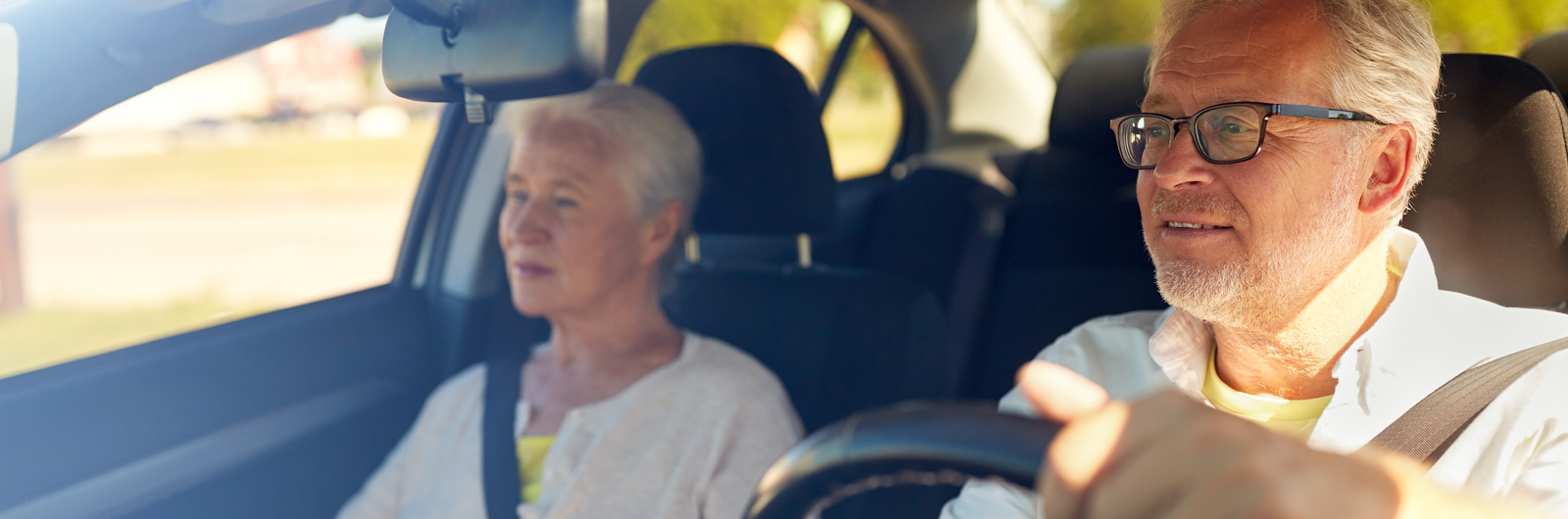 Elderly couple driving in a car.