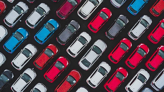 Red, white and blue vehicles in a parking lot.