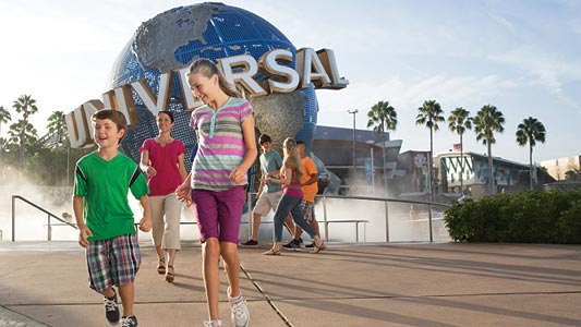 A group of kids standing in front of the Universal Studios globe.