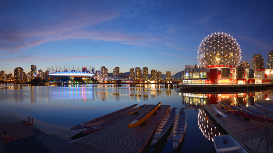 A picture of the Vancouver skyline at night featuring BC Place Stadium and Telus World of Science buildings.