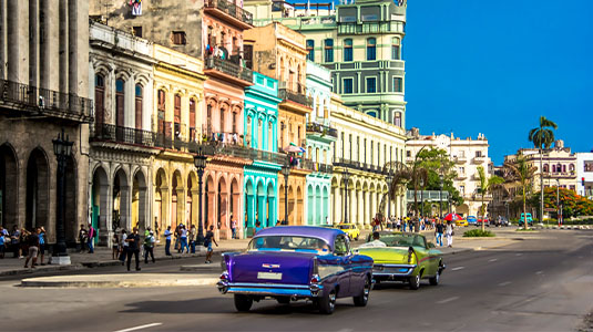 Downtown Havana with old classic cars driving by.