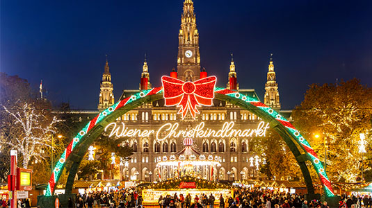 Festive holiday market lit up night in Vienna.