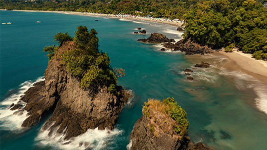 Rocky islets and tropical beach along Costa Rica coast.