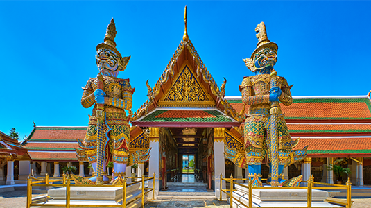 Ornate guardian statues at a Thai temple entrance.