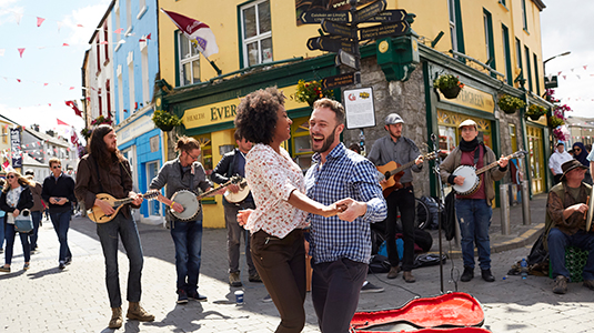 A couple dancing on a street surrounded by musicians.