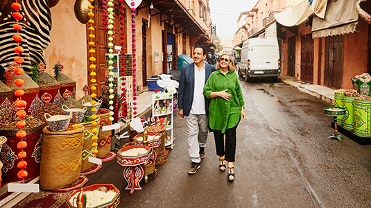 Wide shot of senior couple admiring spice shops while exploring the Medina of Marrakech while on vacation