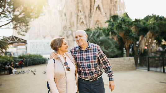 Senior tourist couple walking in front of La sagrada familia, Barcelona. Catalonia, Spain