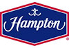 Hampton logo featuring white lettering inside a red hexigonal border with a blue background.