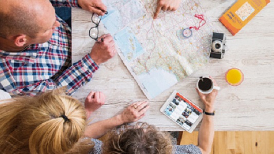 Four people looking at a map on the table.