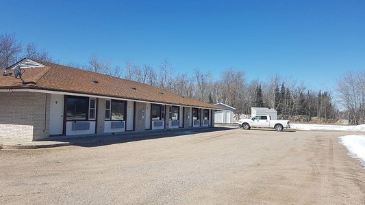 Image showing the exterior of a small motel with a white pickup truck parked outside.