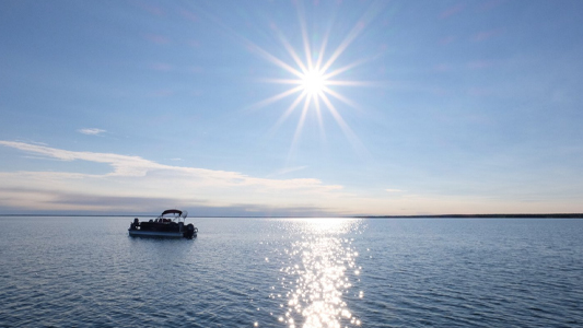 Image showing a lone boat on the lake under a sunny sky.
