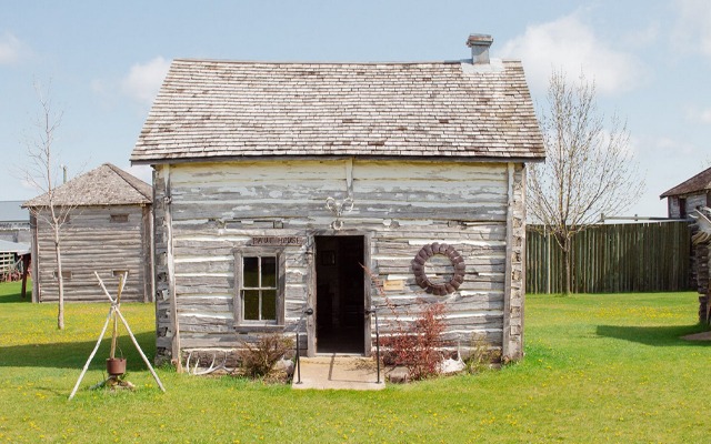 Image showing the exterior of a small pioneer-style house made of logs.