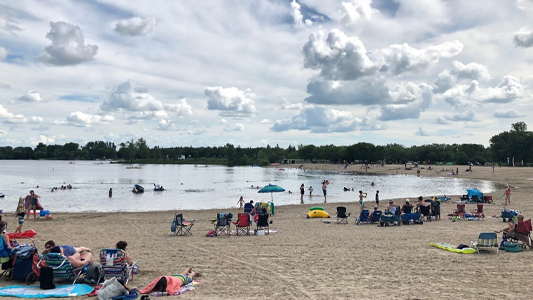 Images showing a beach and lake with sunbathers and swimmers.