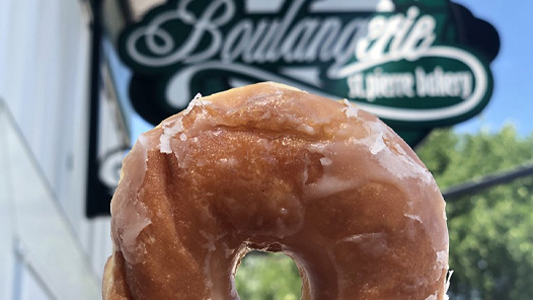 Image showing a closeup of a doughnut with a sign in the background.