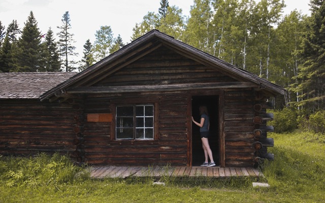 Image showing a large log cabin with trees in the background.