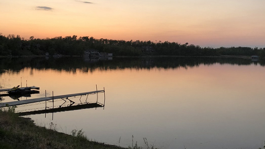 Image showing a tranquil lake in the evening light with a wooden dock in the foreground.