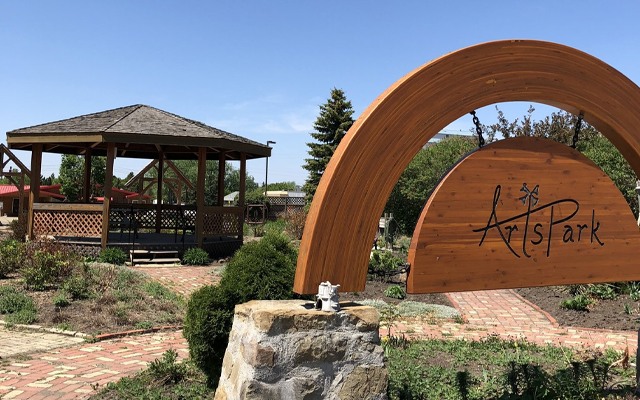 Image showing a gazebo structure in the background with a wooden sign reading Arts Park in the foreground.