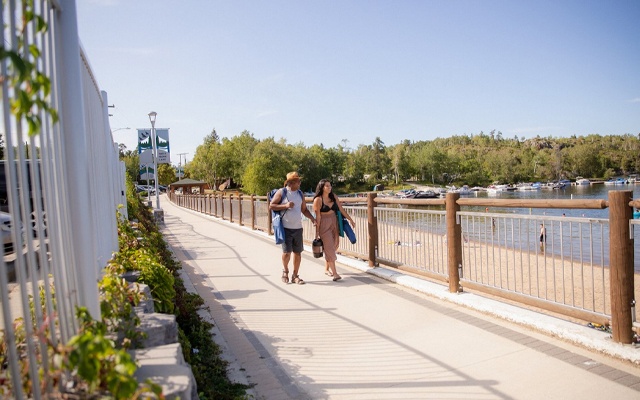 Image showing two people walking along a boardwalk beside a lake.