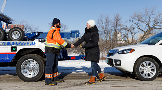 Tow truck driver and member shaking hands